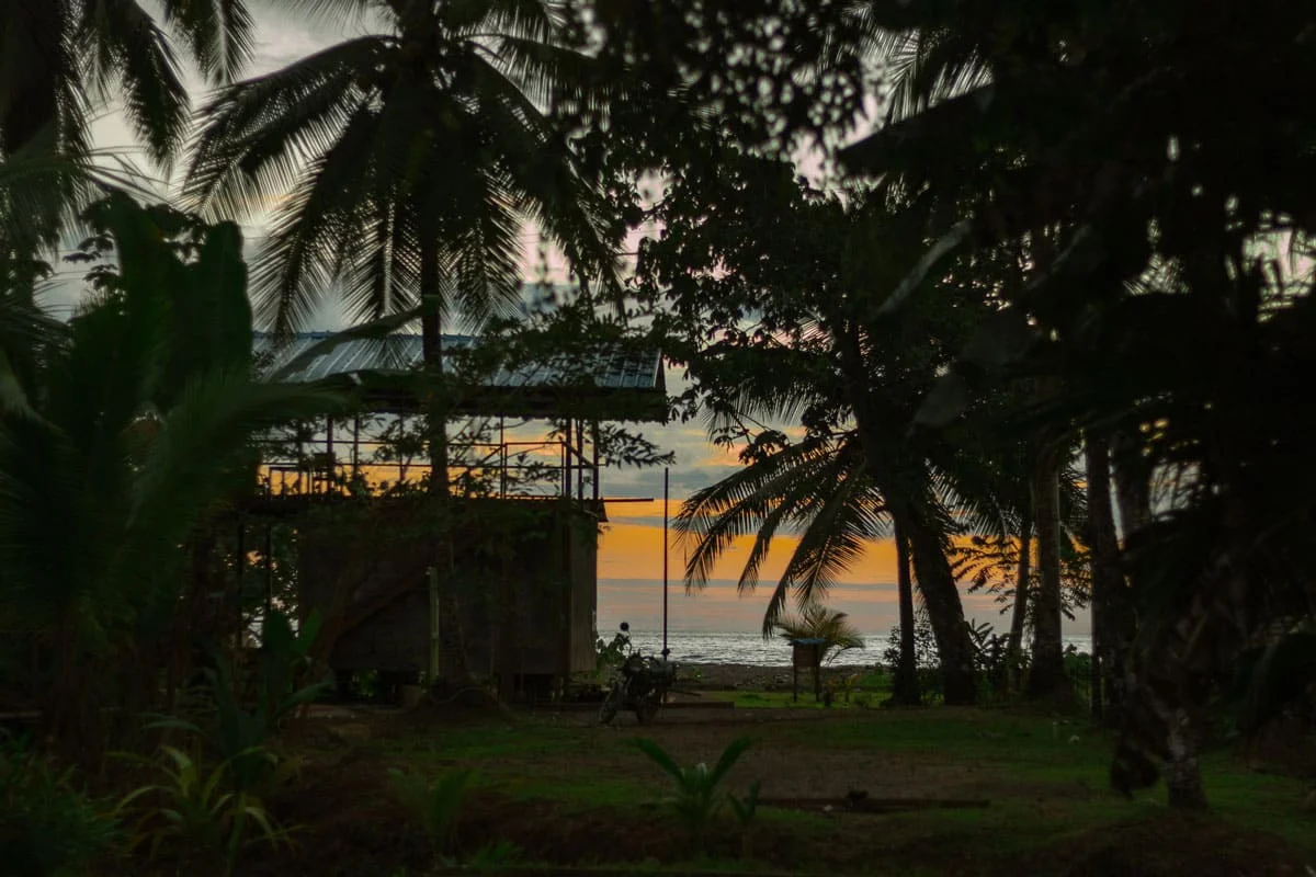 Zona común al aire libre del Pacific Waves Hostel con hamacas y sillas